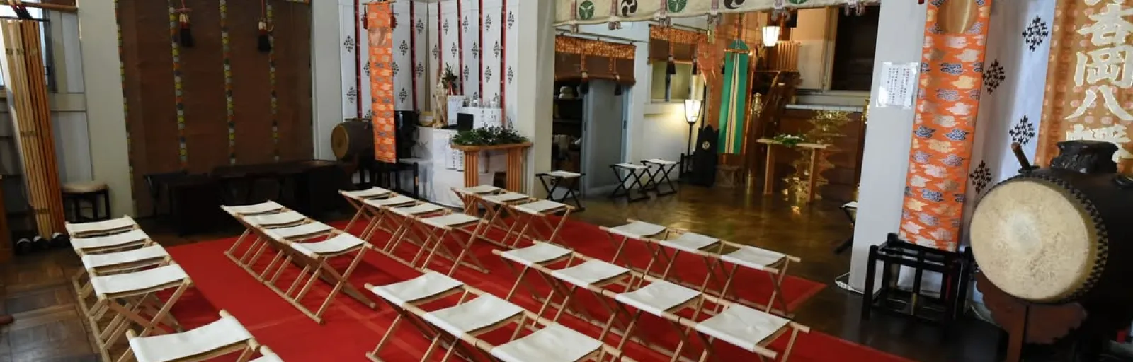 神社の社殿内に並べられた椅子と祭事の準備風景